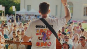 un guitariste sur scène, de dos, face à la foule